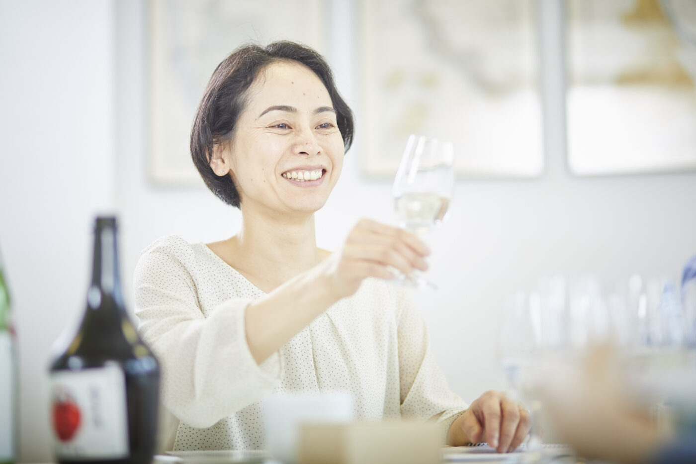 Woman holding up a sake glass and smiling
