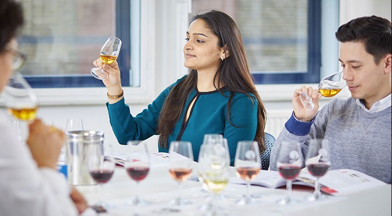 Woman holding up a glass and looking at it