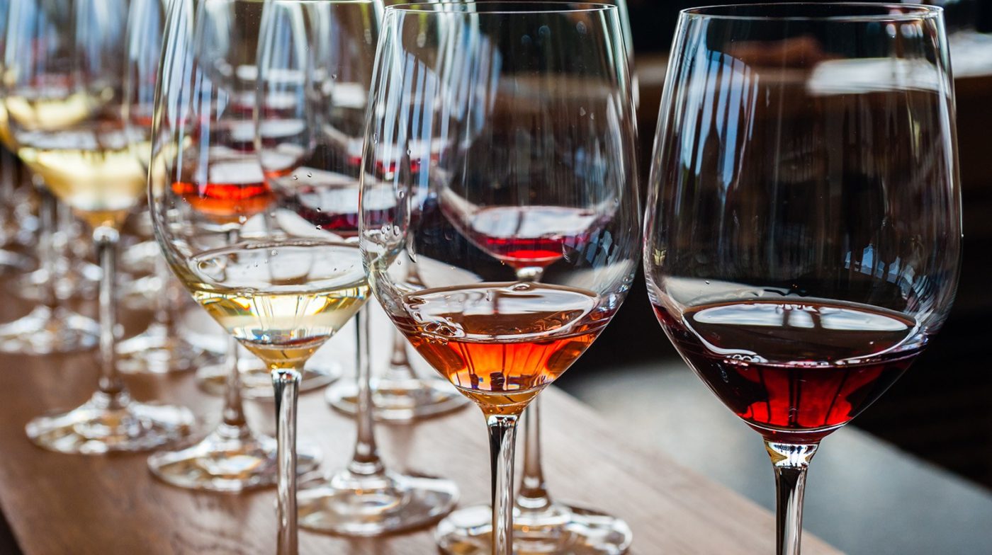 Half-full glasses of red and white wines on a table
