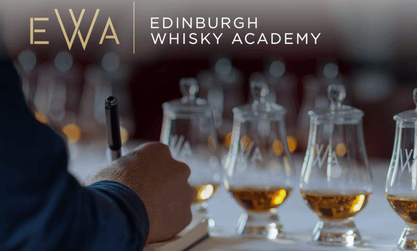 Close up of a hand writing in a notebook with several glasses of whisky in front of them. The text reads  Edinburgh Whisky Academy (EWA).